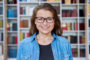 Headshot portrait smiling mature woman teacher in classroom