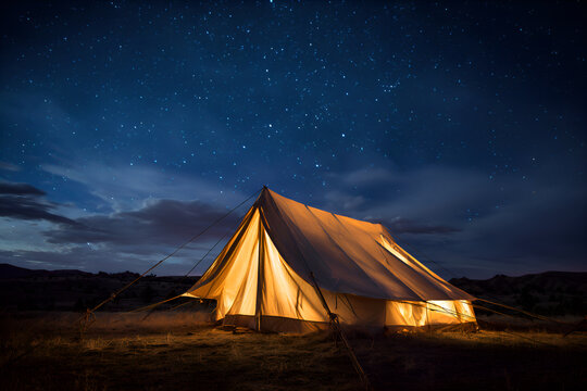 Illuminated tent camping under starry night sky in the desert