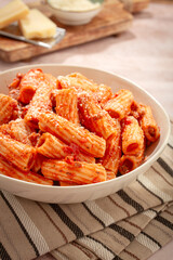 Rigatoni pasta with meat sauce and parmesan cheese on a light table, top view, homemade, no people,