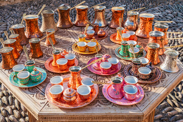 Beautiful copper cezve and cups coffee sets displayed on a table