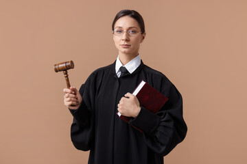 Judge with mallet and book on light brown background