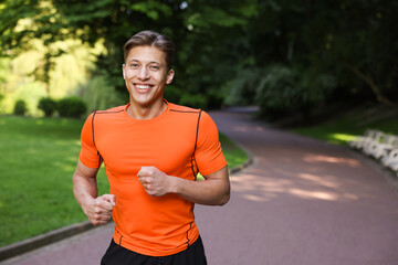 Sporty man running in park, space for text