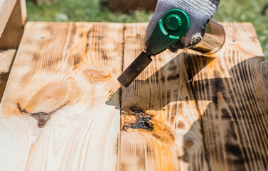 The process of burning wooden boards with a burner. The texture of wood treated with fire from a...