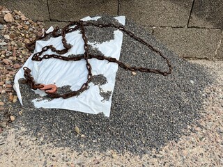 Small pile of gravel with a steel chain and a white sheet to protect against rain or dirt