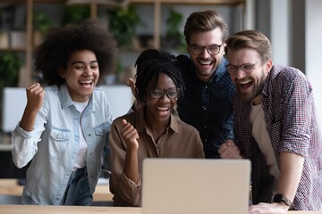 group of staff consist of two man and two woman cheering with laptop in front of them