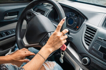 Woman with long nails driving modern car, holding steering wheel
