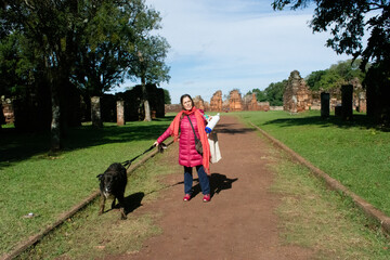 Woman with dog travelling and sightseeing in the jesuit ruins of San Ignacio, Misiones, Argentina