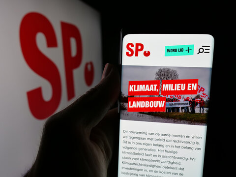 Stuttgart, Germany - 07-09-2025: Person holding smartphone with web page of Dutch party Socialistische Partij (SP) on screen in front of logo. Focus on center of phone display.
