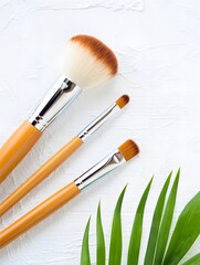 Wooden Makeup Brushes on White Towel with Green Leaf