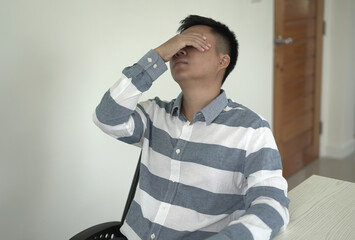 Young asian businessman suffering headache, backache and neck pain while working for so long,...