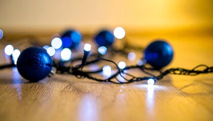 Blue christmas balls and string lights on wooden floor