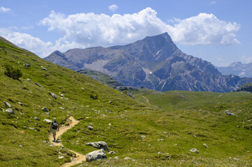 Hiker hikes Alta Via 1 in Dolomites, Italy, an unforgettable alpine experience.