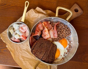 Traditional Breakfast with Fried Eggs, Bacon and Buckwheat in Cafe Setting