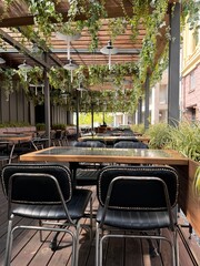 Outdoor Cafe Seating with Greenery and Wooden Pergola