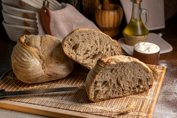 Healthy, organic, whole and sliced ​​homemade sourdough bread with ham and cheese on a wooden...