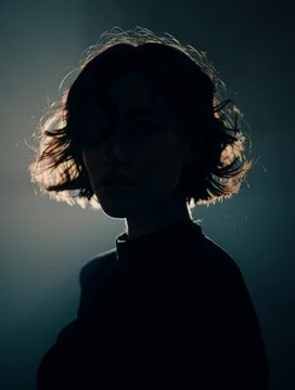 Silhouette profile of woman with soft backlight and dark background