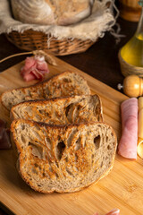 Healthy, organic, whole and sliced ​​homemade sourdough bread with ham and cheese on a wooden...