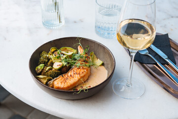Grilled salmon with brussels sprouts and broccoli served for a dinner in a restaurant.
