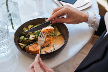 Grilled salmon with brussels sprouts and broccoli served for a dinner in a restaurant.