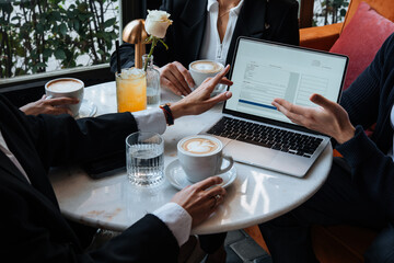 People discussing business projects in a cafe while having coffee.