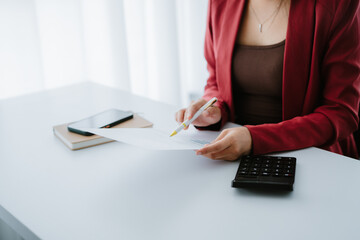 Business woman hand using calculator to calculate the financial results. work from home concept