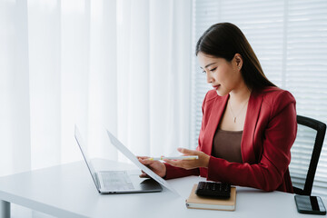 Cropped image of a woman's hand is working with a computer laptop at the wooden working desk.