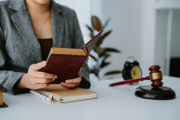 Lawyers discuss a contract on a clipboard, with one pointing to specific terms with a pen, while a...
