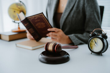 Lawyers discuss a contract on a clipboard, with one pointing to specific terms with a pen, while a...