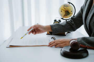 Lawyers discuss a contract on a clipboard, with one pointing to specific terms with a pen, while a...