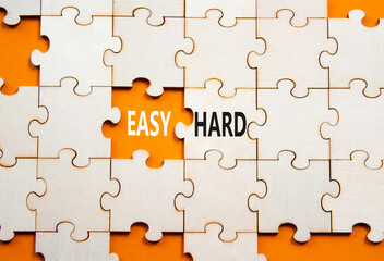 Easy or Hard symbol. Concept word Easy or Hard on wooden puzzle. Beautiful orange background....