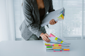 secretary is searching through pile of important documents on office table deliver them to manager...