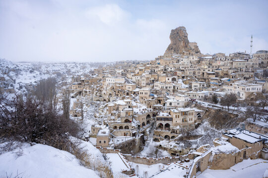 Snow-covered rock formation and a tree in Cappadocia. Breathtaking view of Valley in winter season, Uchisar Ortahisar Cappadocia National park