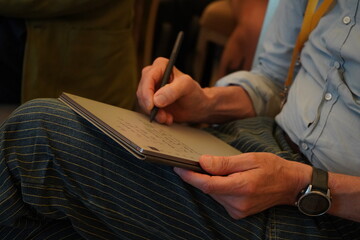 A person takes handwritten notes on a tablet during a conference. Close-up of hands, digital pen...