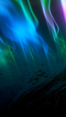 Stylized aurora lights in vibrant green and purple tones above a dark landscape