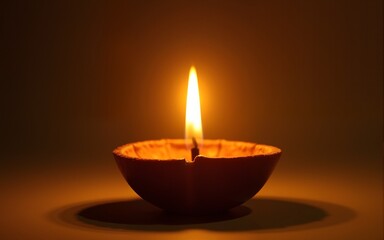 Beautiful golden diya candle with a flickering flame, creating a warm and serene ambiance for festivals and celebrations. High quality