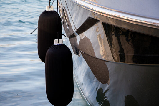 Black Boat Fenders Protecting a Shiny Yacht Hull - Powered by Adobe