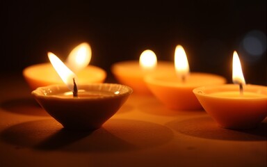 Candles lit during a religious ceremony or celebration, possibly Diwali. The lights create a warm glow. High quality