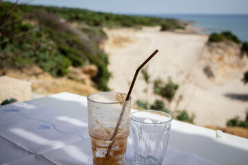 Empty Glasses on a Table Overlooking a Coastal Landscape