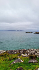 Overcast Coastal View with Rocky Shoreline and Distant Islands in Ireland