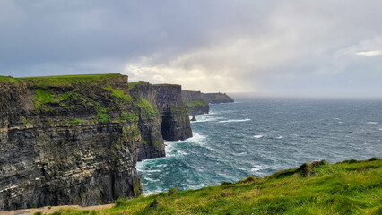 Expansive View of the Cliffs of Moher and Atlantic Ocean under Stormy Skies