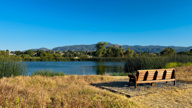 lake in the mountains, beautiful landscape with wooden bench by lake in California mountains, Tehachapi, on a sunny summer day with blue cloudless sky as a backdrop or natural background. Harmony.