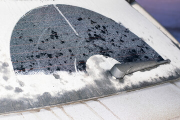 dirty rear window of a car with a wiper