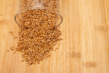 A super close-up of flaxseeds on a wooden table.