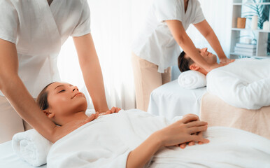 Obraz premium Caucasian couple customer enjoying relaxing anti-stress spa massage and pampering with beauty skin recreation leisure in day light ambient salon spa at luxury resort or hotel. Quiescent