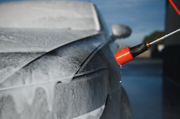 Car wash equipment. A man is washing a car at self service car wash. High pressure vehicle washer...
