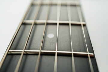 Close-up image of a well-used guitar, showcasing craftsmanship and passion Fretboard details, slightly faded string, soft gray background, potential studio or personal setting Suitable for ads rela
