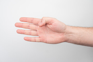 Close-up of a light-skinned, finger-curled human hand against a neutral background, with soft...