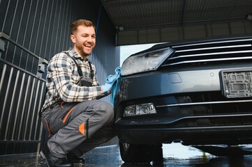 Car detailing - the man holds the microfiber in hand and polishes the car. Selective focus