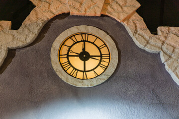 Modern Christmas clock tower, illuminated with warm light and set within a rugged architectural...