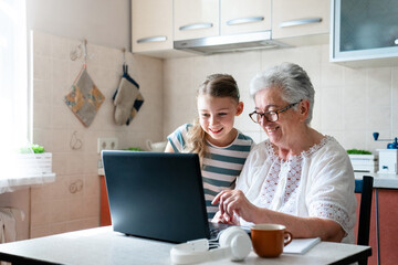 Child helping grandmother learning computer skills. Digital literacy, education and support. Kid...